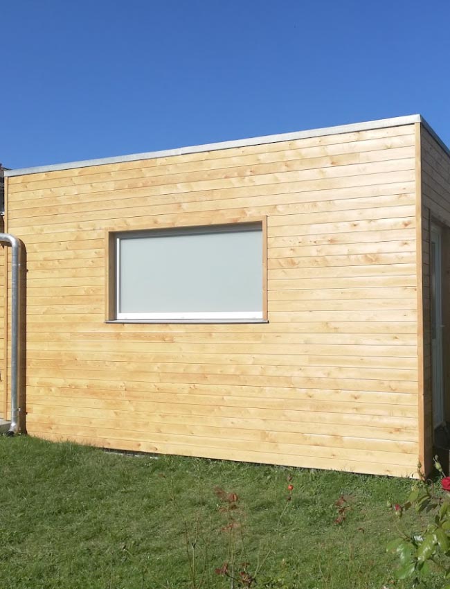 Badage de bois clair posé sur une extension de jardin